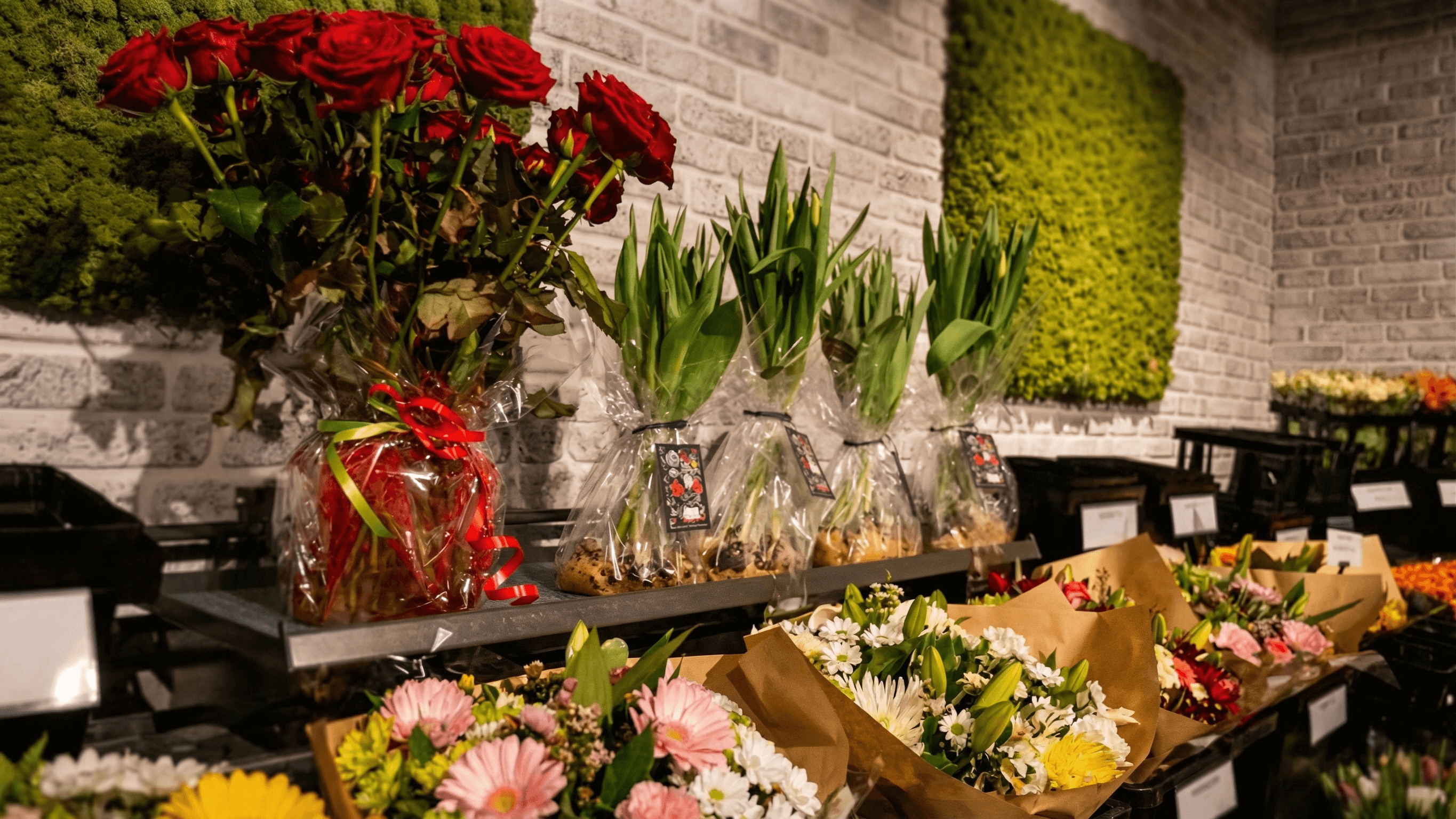 Bouquets and potted tulips displayed with Porto vases in a retail flower shop